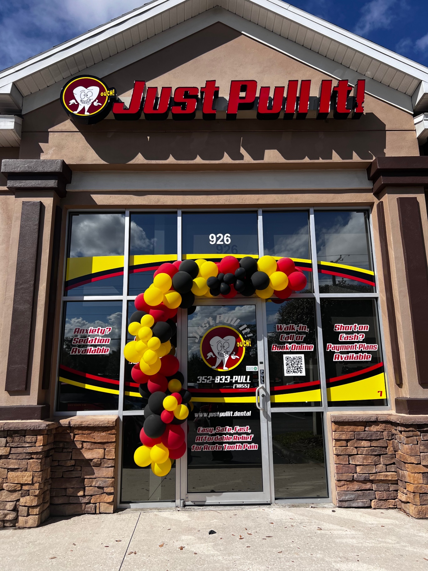 Just Pull It Brandon storefront with grand opening balloon arch