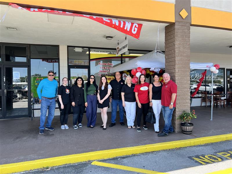 Team lined up outside the Port Richey storefront under the Grand Opening banner