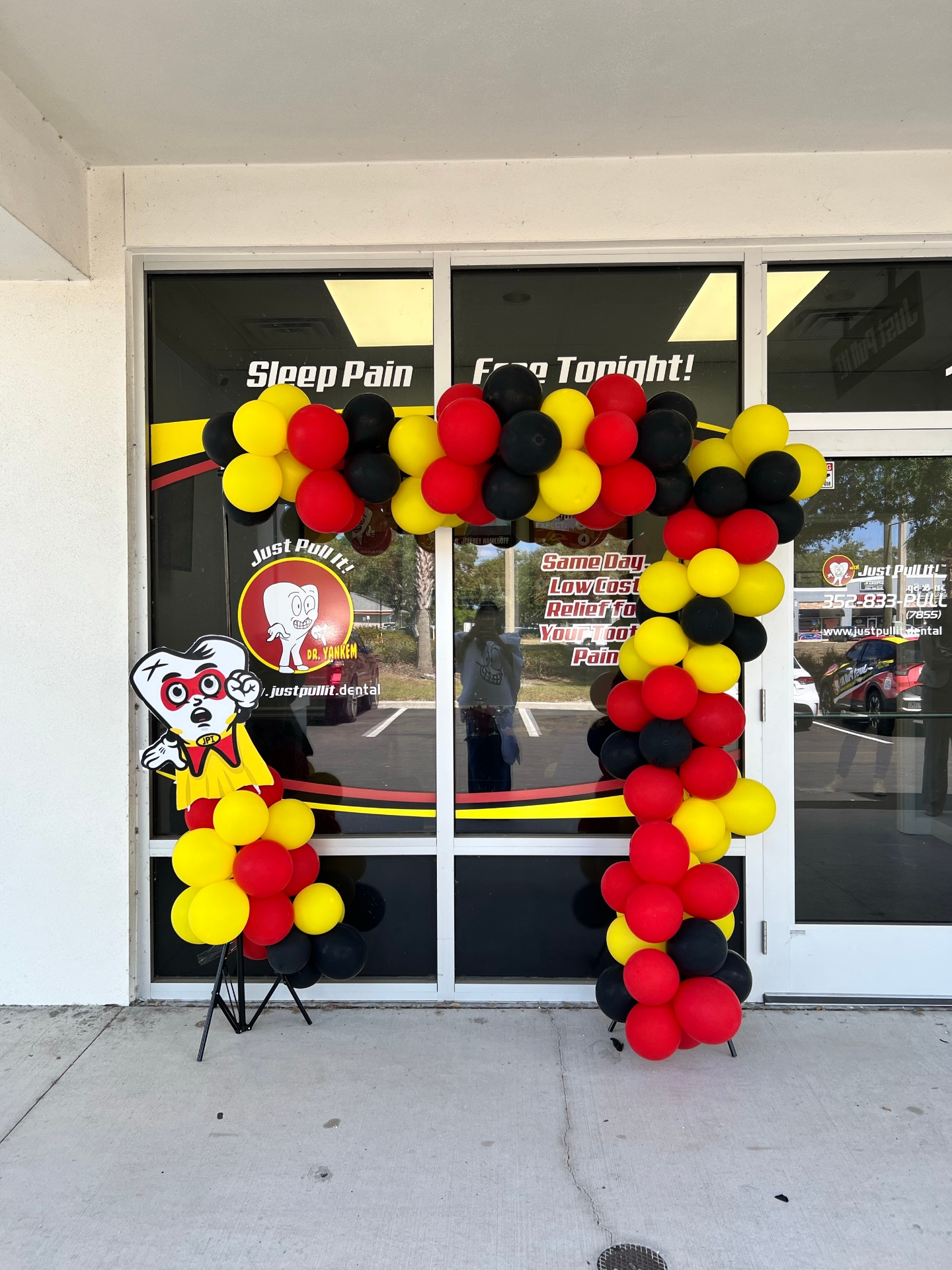 Balloon arch and mascot cutout at the Lutz office entrance